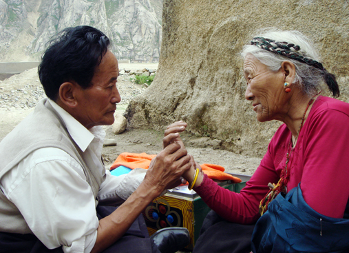 Старший тибетский врач читает пульс пациентки на обочине дороги, Центральный Тибет, 2007 год